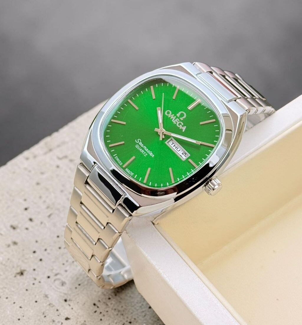 Omega men’s analog watch featuring a classic round case, stainless steel chain bracelet, working day and date display, quartz movement, and luxury-inspired styling. Burberry Women's Watch – Elegant Date Display Watch with Classic Luxury Styling