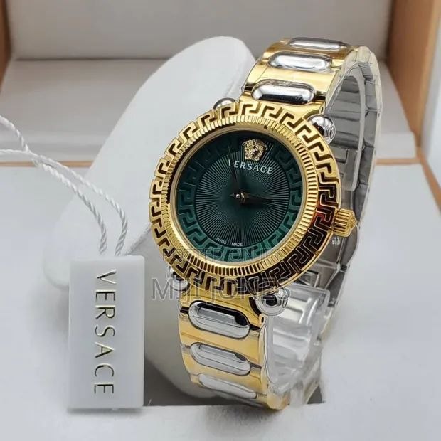 Versace VE6I00423 Women's Watch featuring a luxurious gold dial, two-tone stainless steel bracelet, iconic Greek Key bezel, scratch-resistant mineral glass, and reliable quartz movement. Versace VE6I00423 women's watch featuring a luxurious gold dial, two-tone stainless steel bracelet, iconic Greek Key bezel design, mineral glass protection, and elegant luxury-inspired styling.